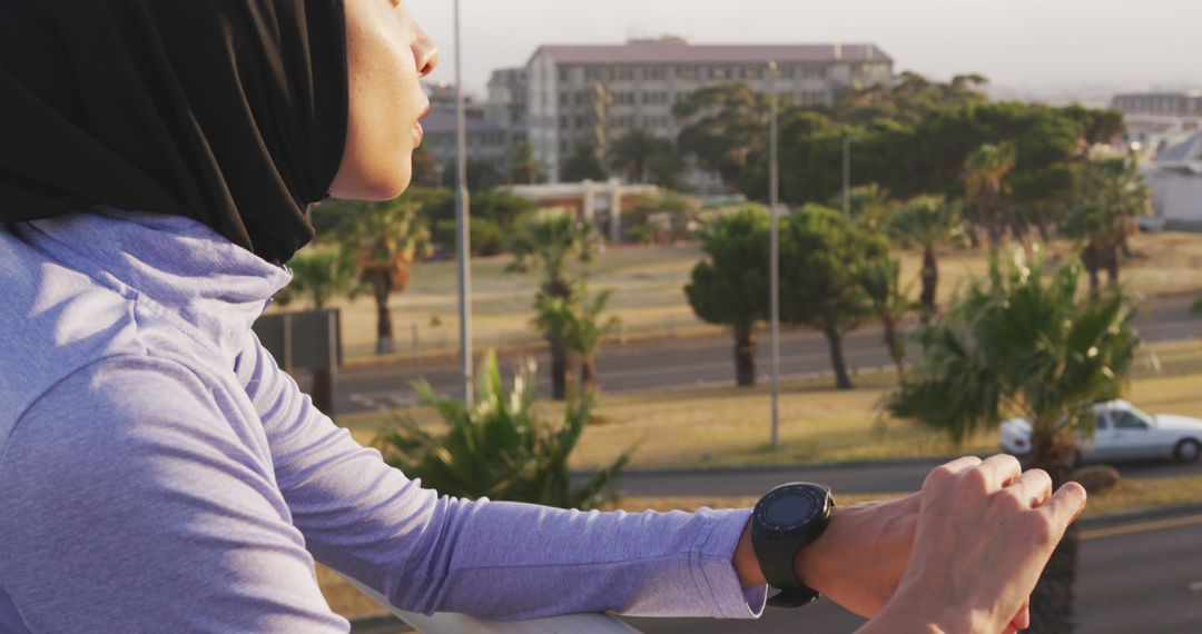 Muslim Woman in Athletic Wear Leaning on Railing Outdoors - Free Images, Stock Photos and Pictures on Pikwizard.com