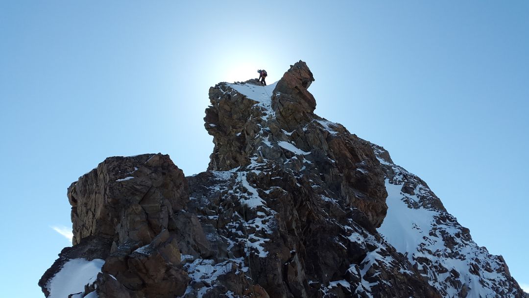 Alpinists Ascending Snowy Mountain on Clear Day - Free Images, Stock Photos and Pictures on Pikwizard.com