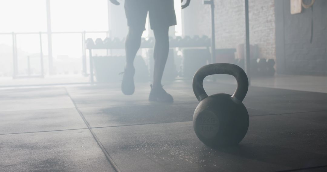 Man Working Out in Gym with Kettlebell and Dumbbells