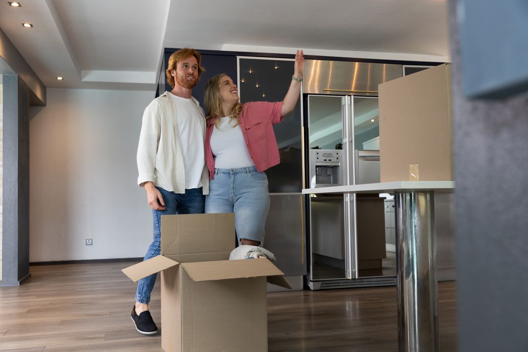 Couple Unpacking Moving Boxes in Modern Kitchen