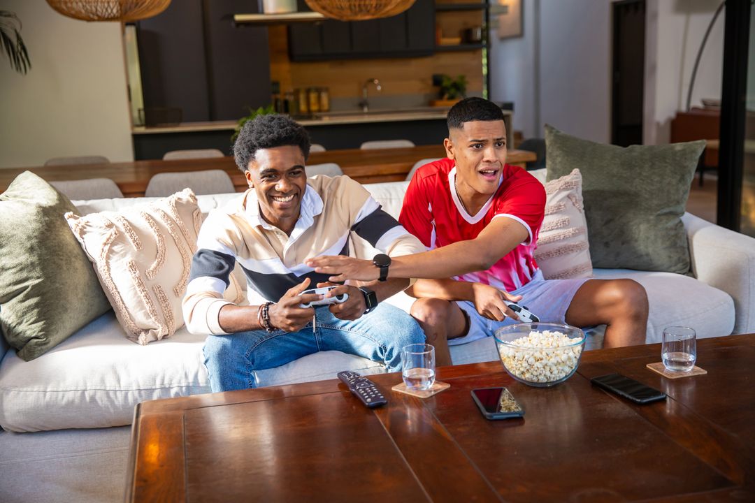 Friends Gaming Together on Sofa with Popcorn