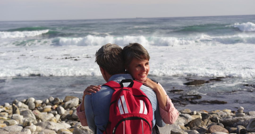 Senior Couple Embracing by Ocean on Rocky Beach - Free Images, Stock Photos and Pictures on Pikwizard.com