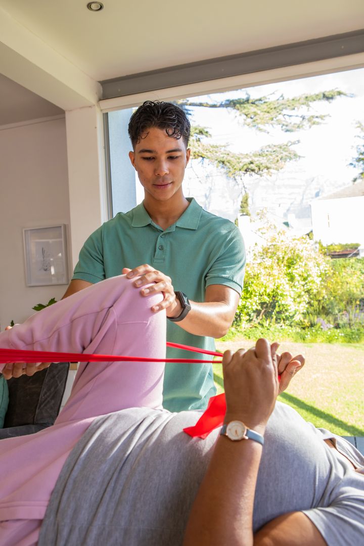 Physiotherapist Guide Patient with Resistance Band Exercise at Home