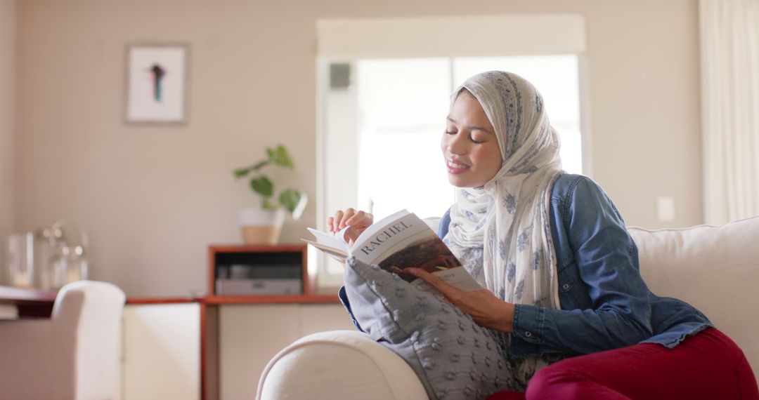 Woman in Hijab Relaxing at Home Reading Book - Free Images, Stock Photos and Pictures on Pikwizard.com