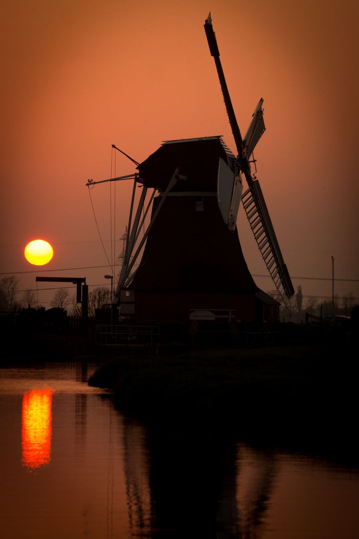 Traditional Windmill Silhouette at Sunset Reflecting Over Water - Free Images, Stock Photos and Pictures on Pikwizard.com