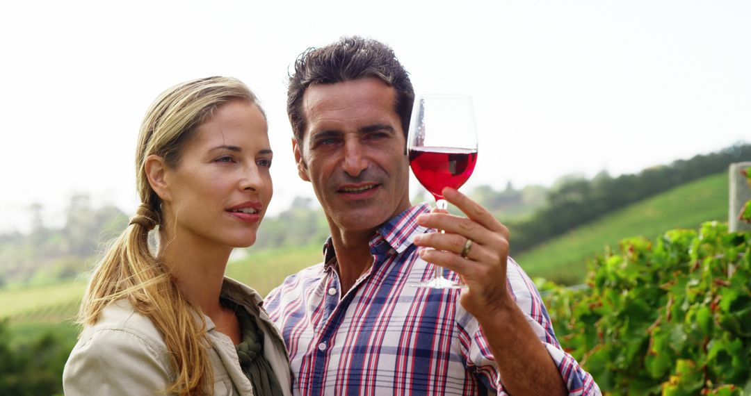 Couple Enjoying Red Wine Amidst Vineyard Scenery