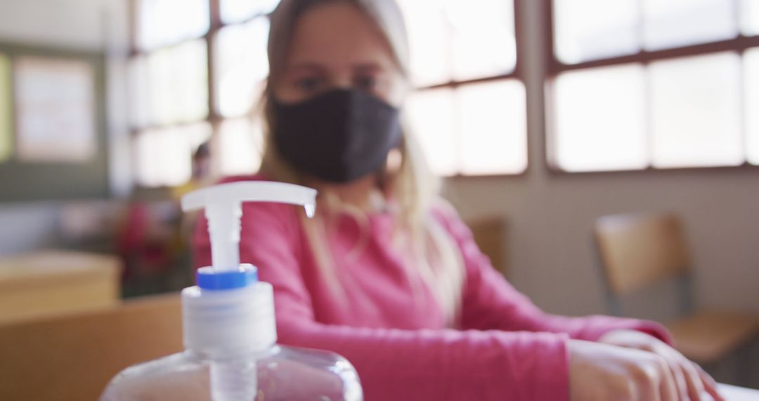 Child in Classroom Wearing Face Mask with Hand Sanitizer - Free Images, Stock Photos and Pictures on Pikwizard.com