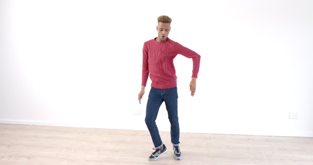 Young Man Dynamically Dancing on Wooden Floor