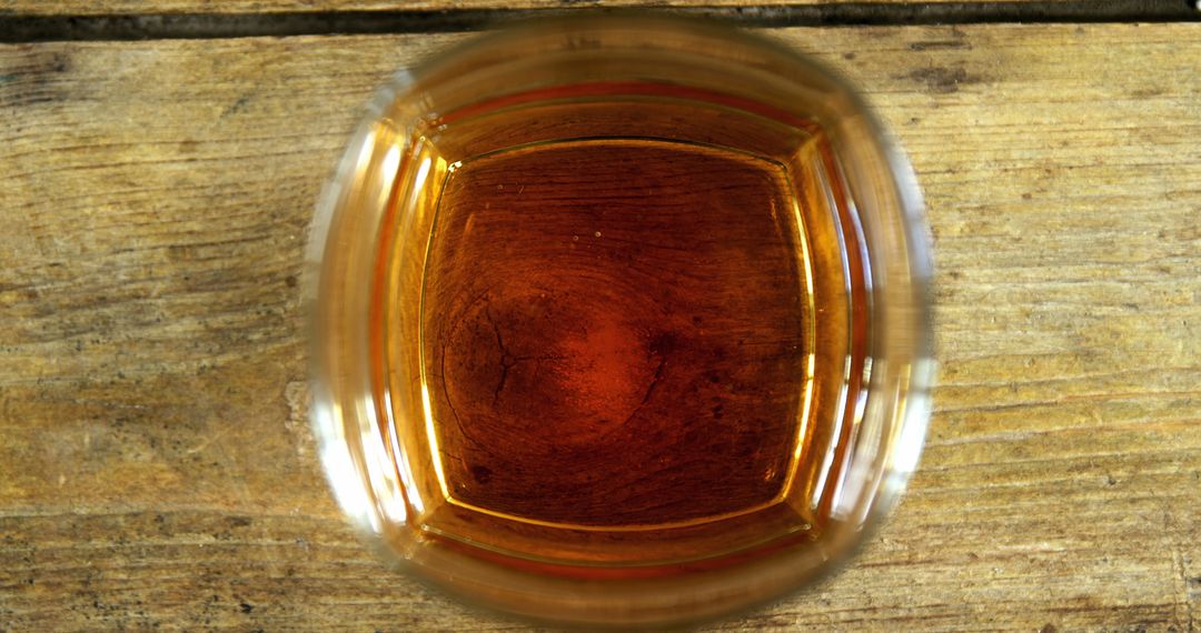 A glass of amber-colored liquid, whiskey or tea, sits atop a rustic wooden surface, with copy space - Free Images, Stock Photos and Pictures on Pikwizard.com