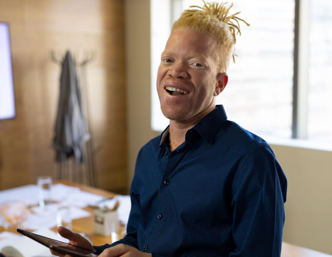 Smiling Professional Using Tablet in Modern Sunny Office