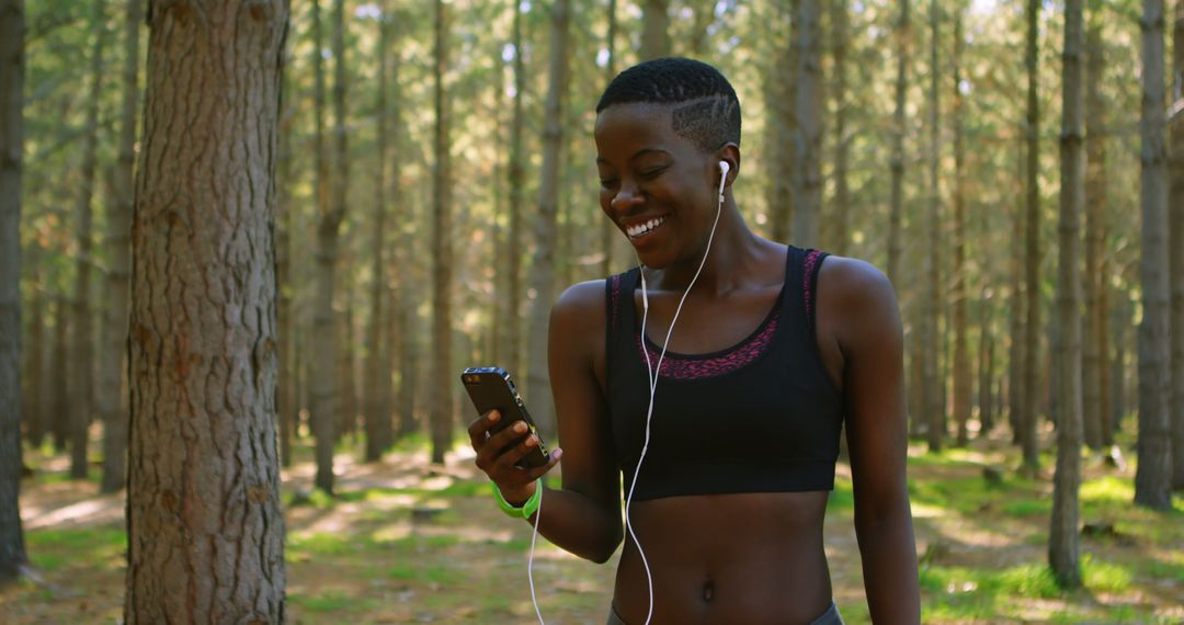 Happy Woman in Sportswear Listening to Music During Forest Run - Free Images, Stock Photos and Pictures on Pikwizard.com