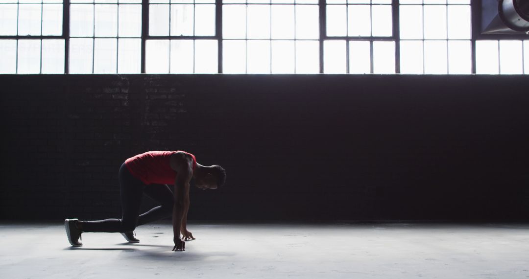 Athletic Man Stretching in Urban Gym with Large Windows - Free Images, Stock Photos and Pictures on Pikwizard.com