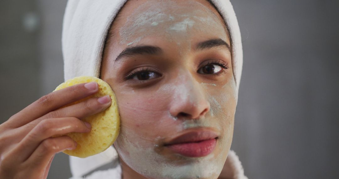 Young Woman Applying Face Mask with Sponge for Skincare Routine - Free Images, Stock Photos and Pictures on Pikwizard.com