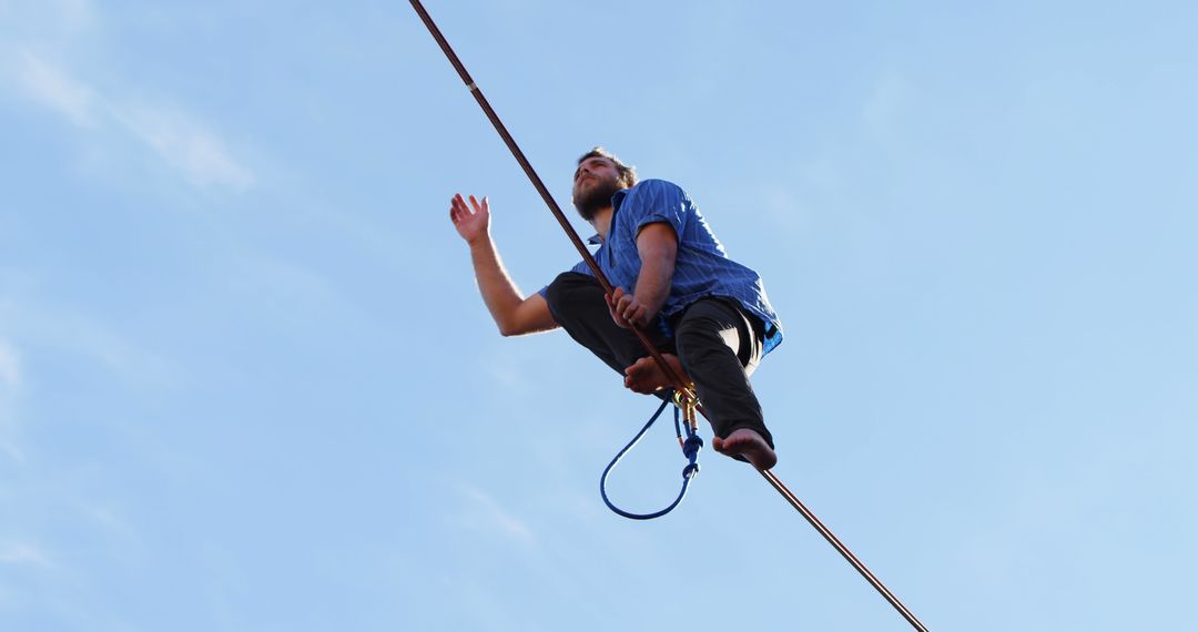 Man Walking on Tightrope Against Clear Blue Sky - Free Images, Stock Photos and Pictures on Pikwizard.com