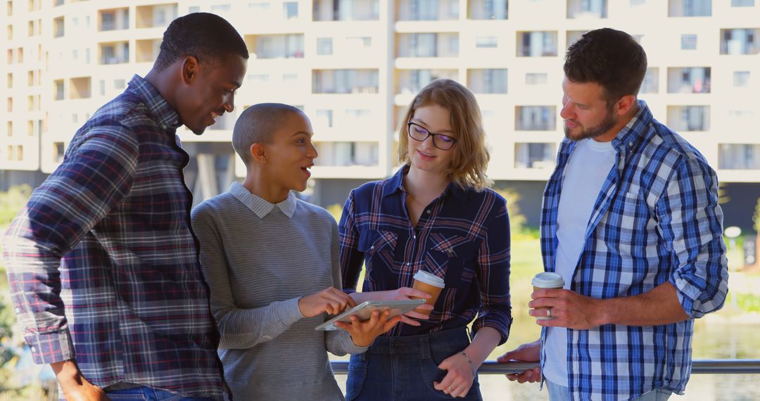 Diverse Team Collaborating Outdoors Using Tablet
