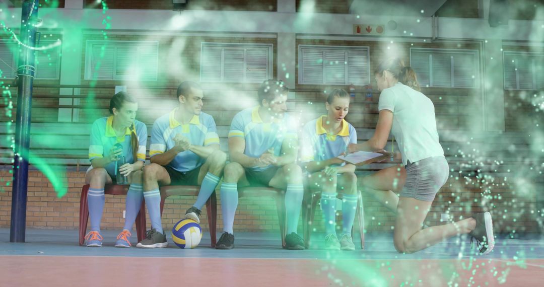Volleyball Coach Strategizing with Team on Gym Bench