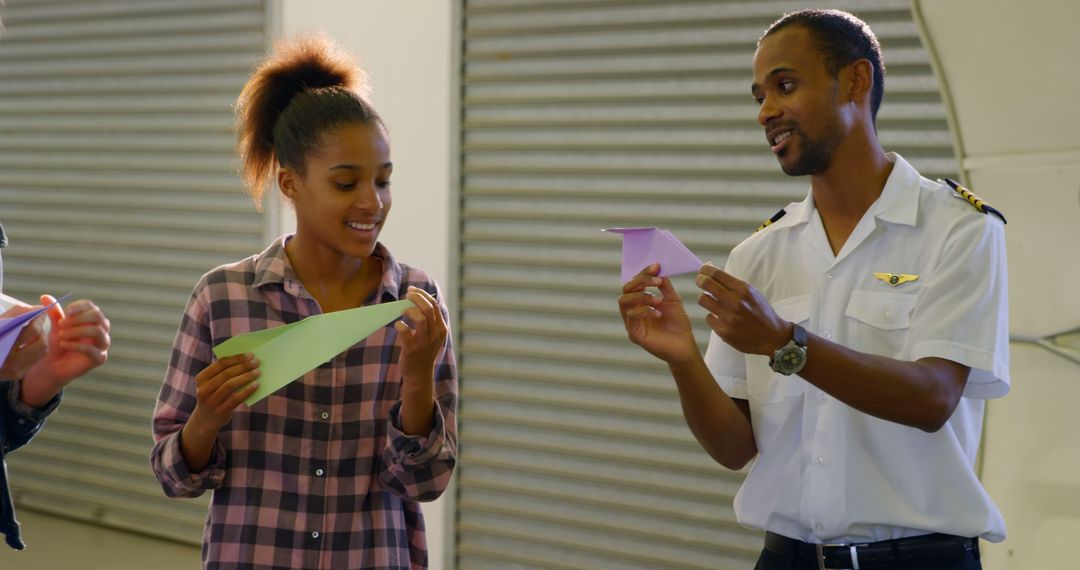 Pilot Teaching Young Girl How to Make Paper Airplanes in Hangar - Free Images, Stock Photos and Pictures on Pikwizard.com