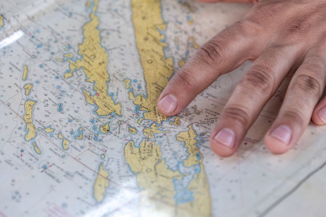 Finger Pointing at Nautical Chart During Coastal Navigation and Route Planning