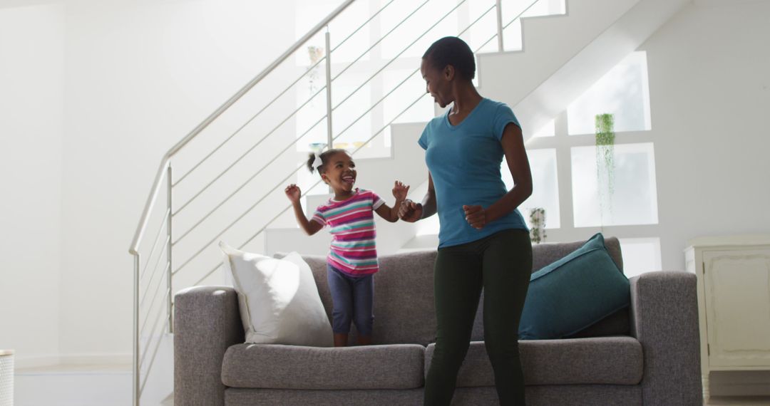 Mother and Daughter Joyfully Dancing in Modern Living Room - Free Images, Stock Photos and Pictures on Pikwizard.com