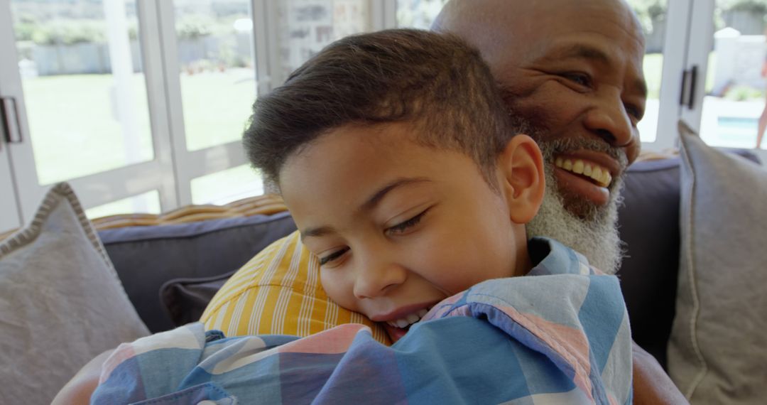 Grandfather and Grandson Embracing in Living Room - Free Images, Stock Photos and Pictures on Pikwizard.com