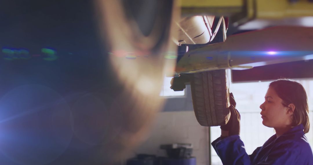 Female Mechanic in Workshop Fixing Vehicle Tire