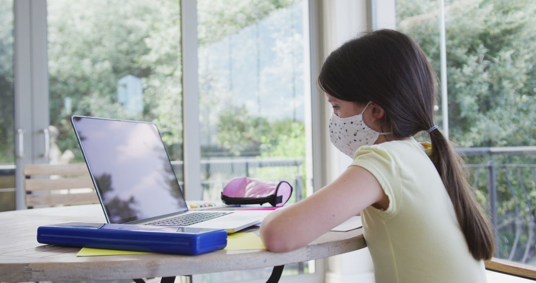 Girl Studying Online at Home While Wearing Mask - Free Images, Stock Photos and Pictures on Pikwizard.com