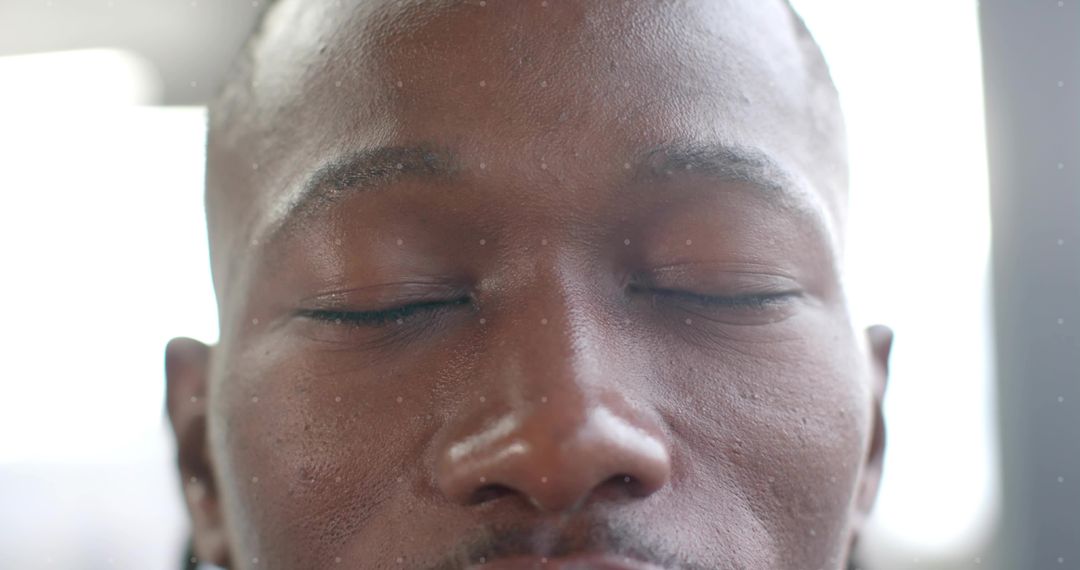 Close-up serene male portrait with eyes closed highlighting skin texture and natural light