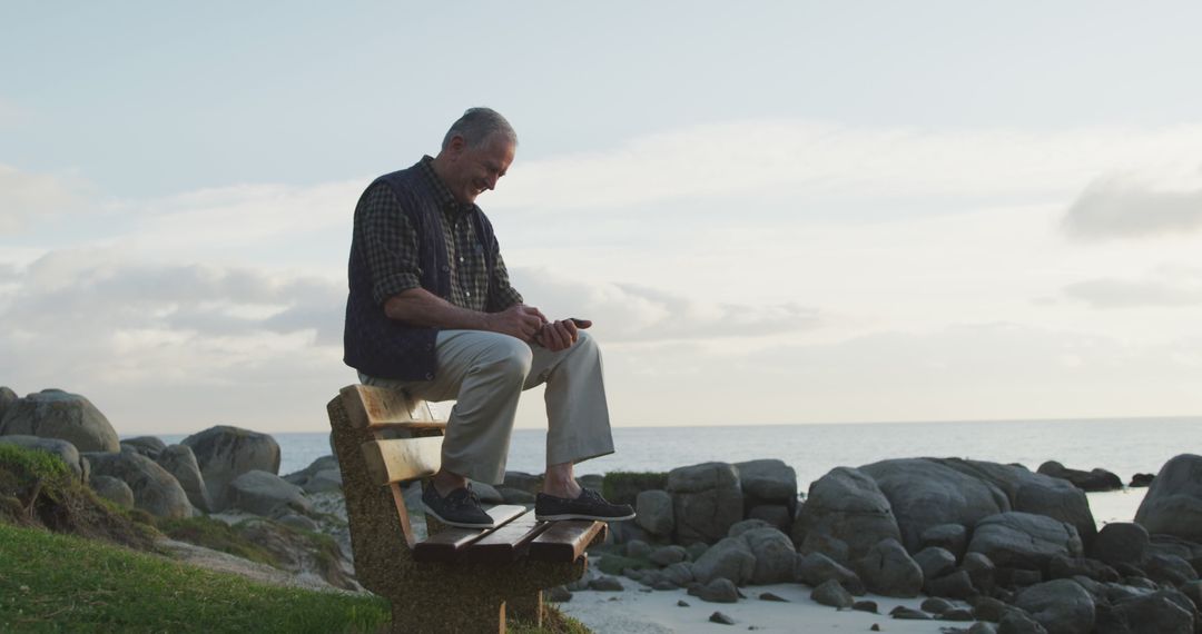 Senior man sitting on beachside bench enjoying sunset - Free Images, Stock Photos and Pictures on Pikwizard.com