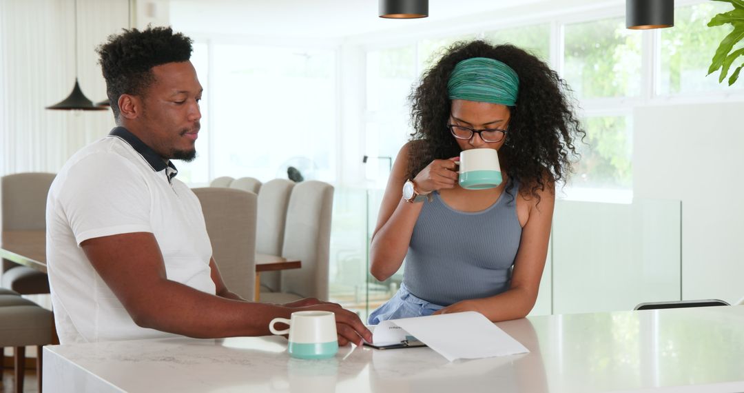 Couple Discussing Together Over Coffee in Modern Kitchen