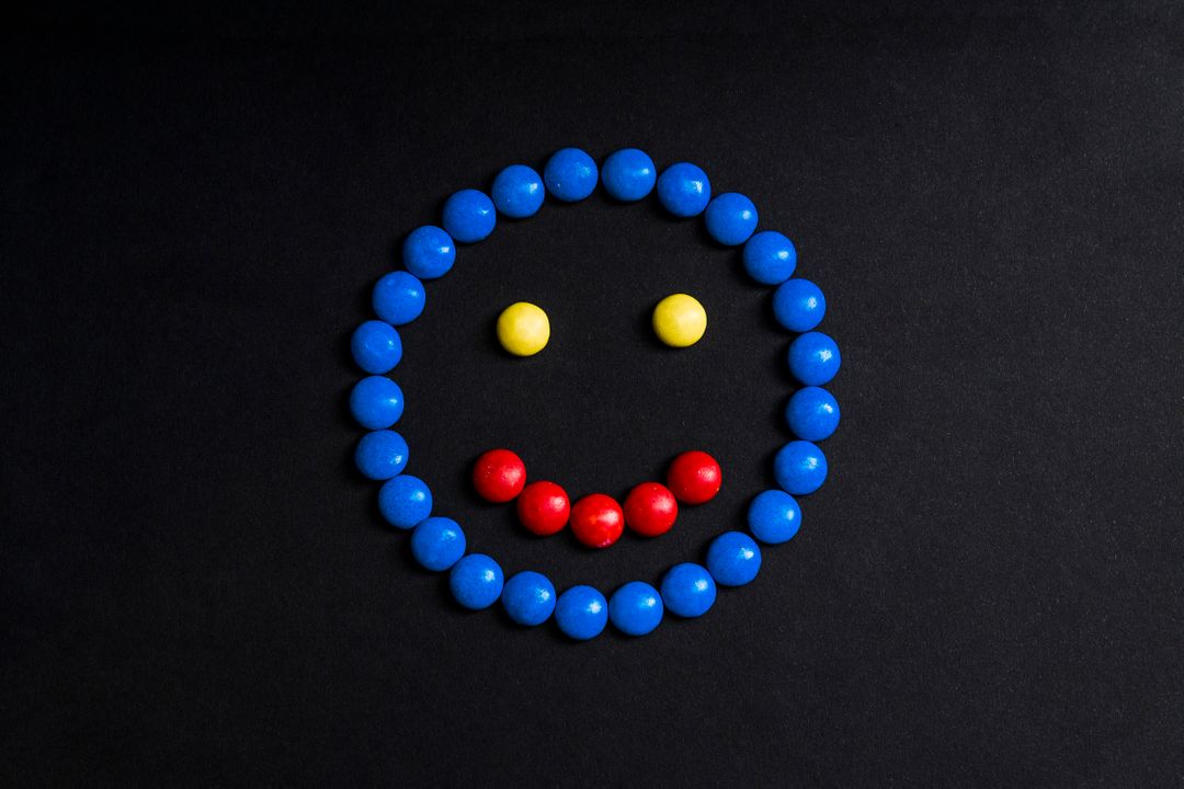 Smiling Face Made with Colorful Candies on Black Background - Free Images, Stock Photos and Pictures on Pikwizard.com