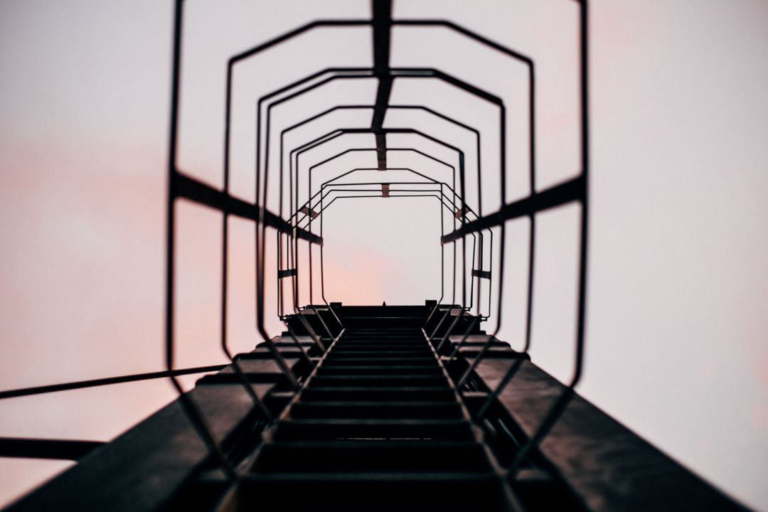 Looking Up Industrial Ladder Cage Against Pink Sky at Dusk - Free Images, Stock Photos and Pictures on Pikwizard.com