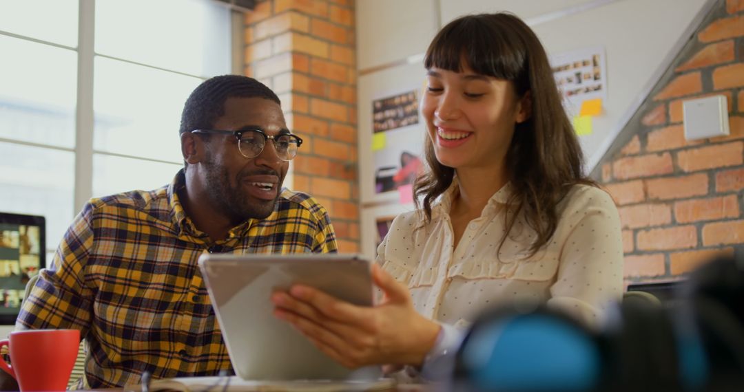 Diverse Designers Collaborating Using Digital Tablet in Modern Office