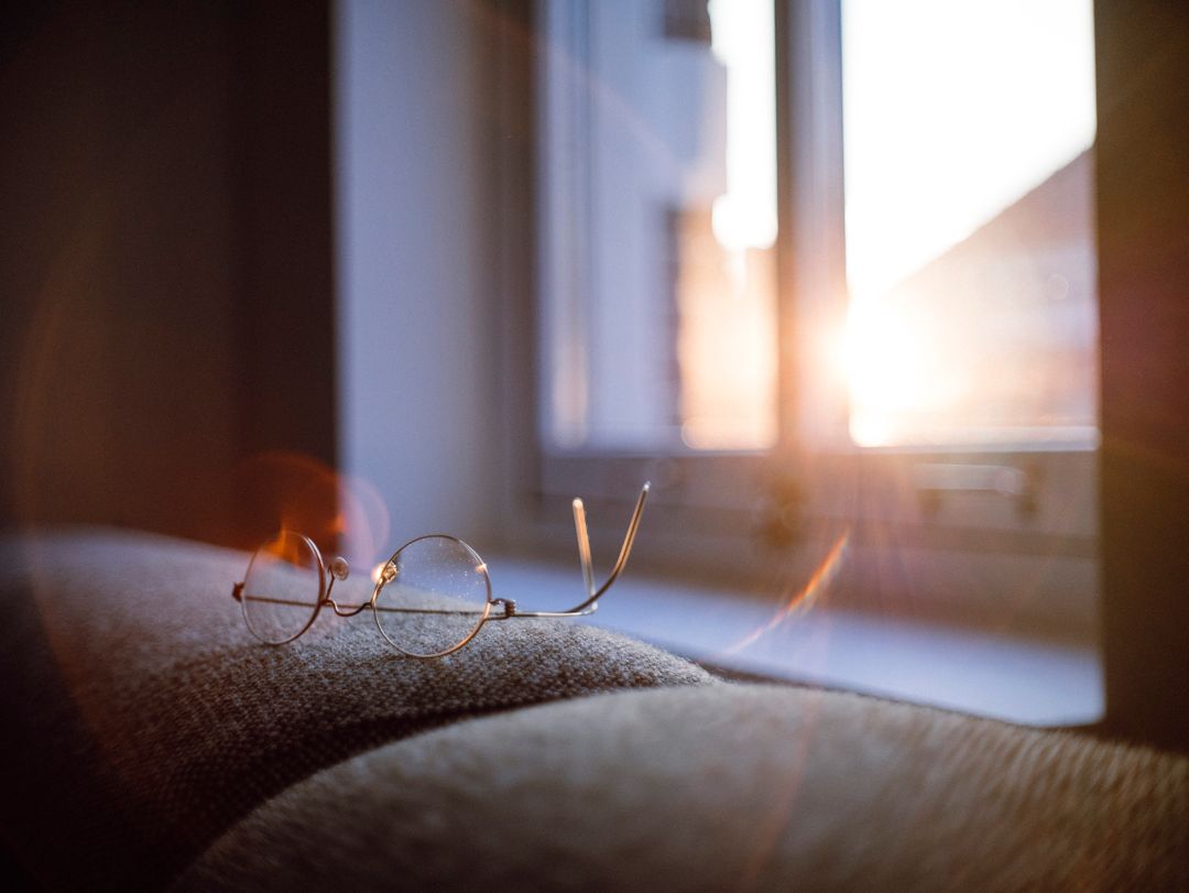 Vintage Eyeglasses on Couch with Sunlight Coming Through Window - Free Images, Stock Photos and Pictures on Pikwizard.com