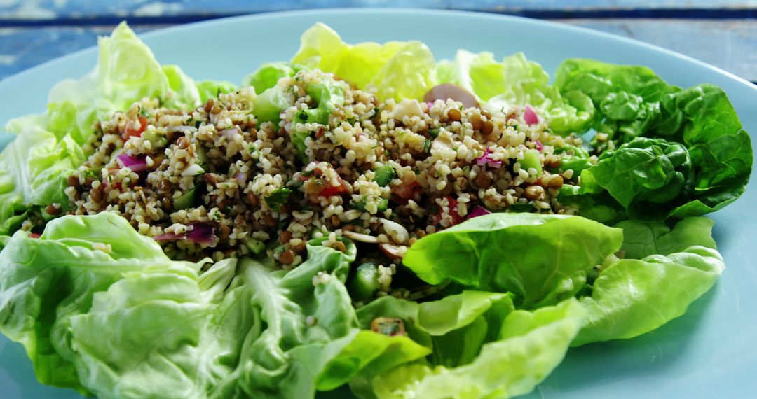 A healthy quinoa salad served on a bed of crisp lettuce leaves, with copy space - Free Images, Stock Photos and Pictures on Pikwizard.com
