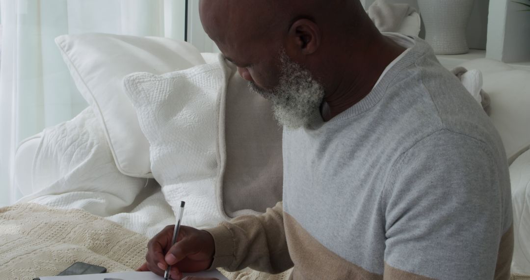 Man Writing in Notebook at Home - Free Images, Stock Photos and Pictures on Pikwizard.com