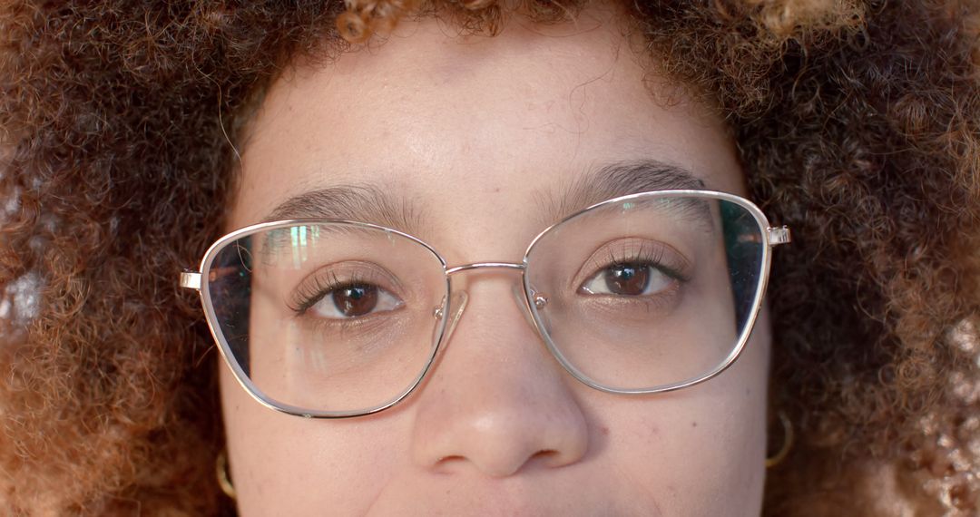 Close-Up of Woman with Curly Hair and Glasses Smiling - Free Images, Stock Photos and Pictures on Pikwizard.com