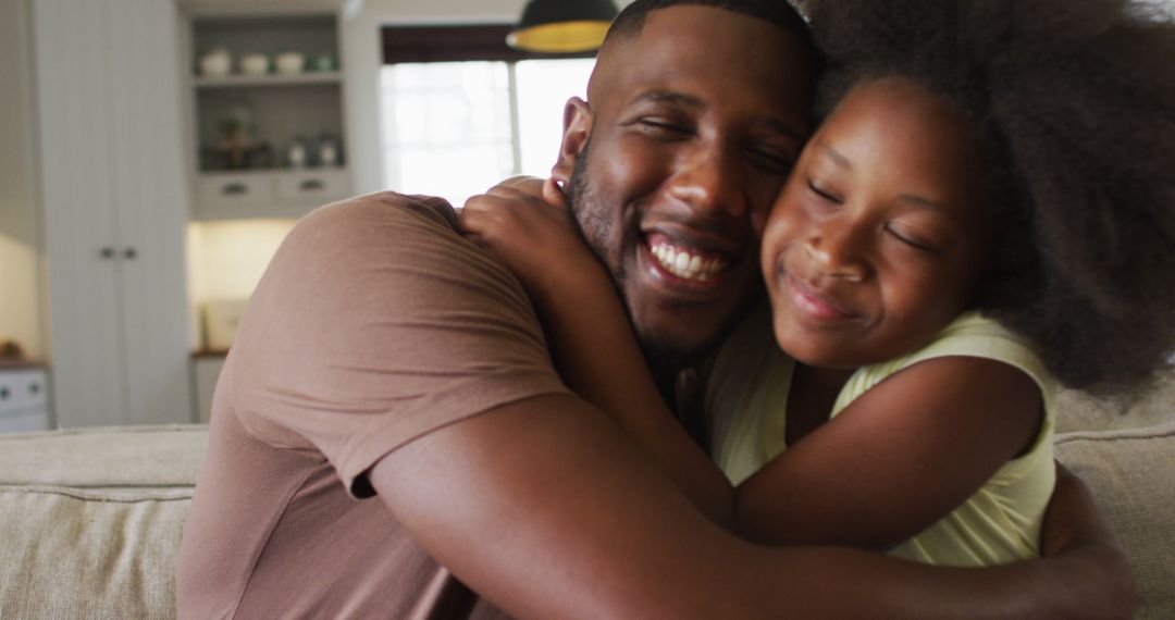 Smiling Father Hugging Happy Daughter on Sofa - Free Images, Stock Photos and Pictures on Pikwizard.com