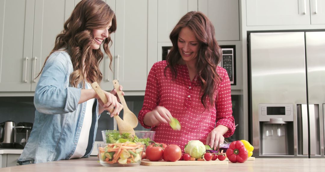 Smiling Women Preparing Fresh Salad in Modern Kitchen - Free Images, Stock Photos and Pictures on Pikwizard.com