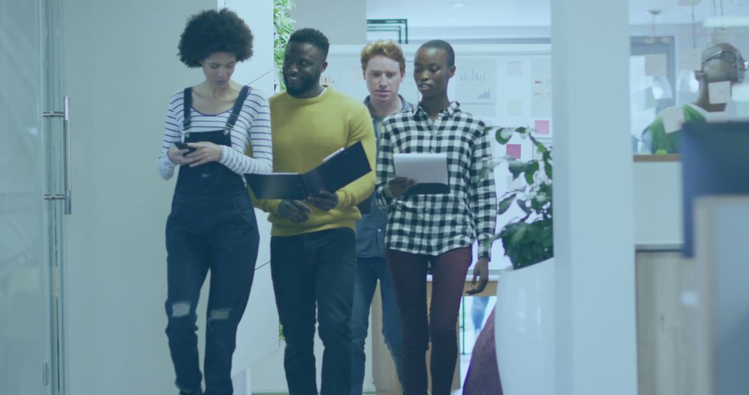 Diverse Colleagues Walking Through Office Hallway Sharing Ideas