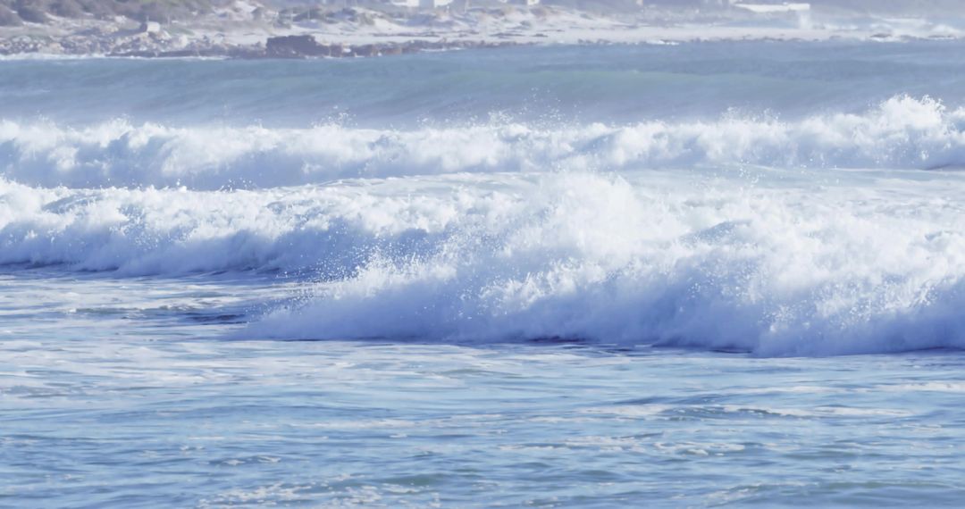 Breaking Turquoise Ocean Waves Rolling Into Rocky Shoreline With White Foam Spray
