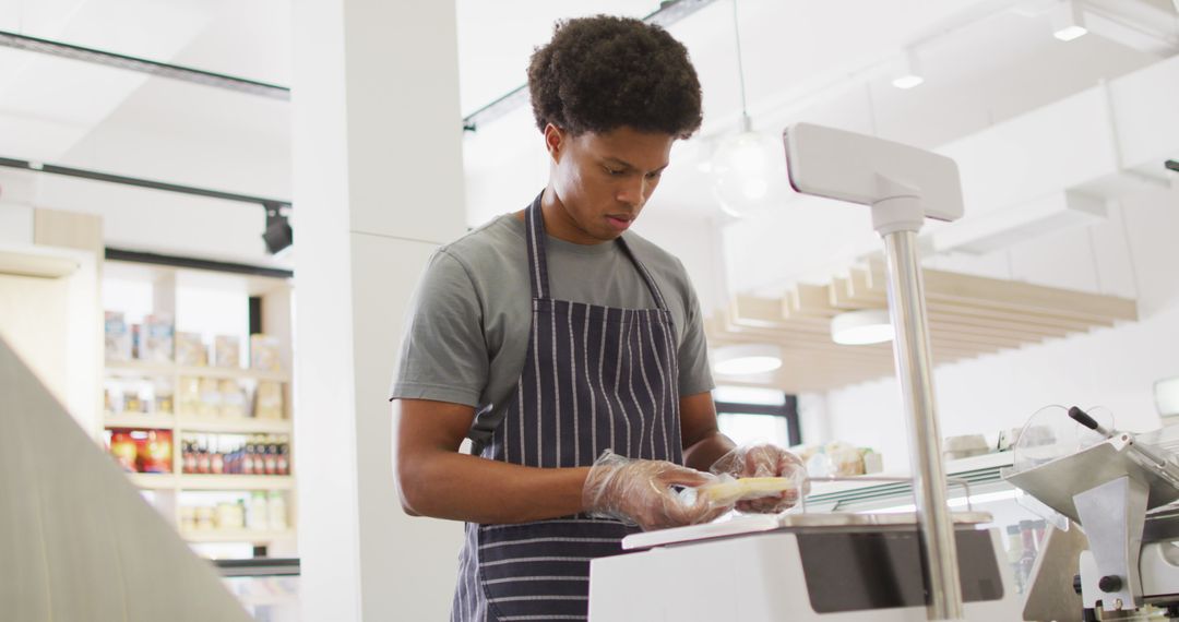 Image of focused biracial waiter weighting cheese - Free Images, Stock Photos and Pictures on Pikwizard.com