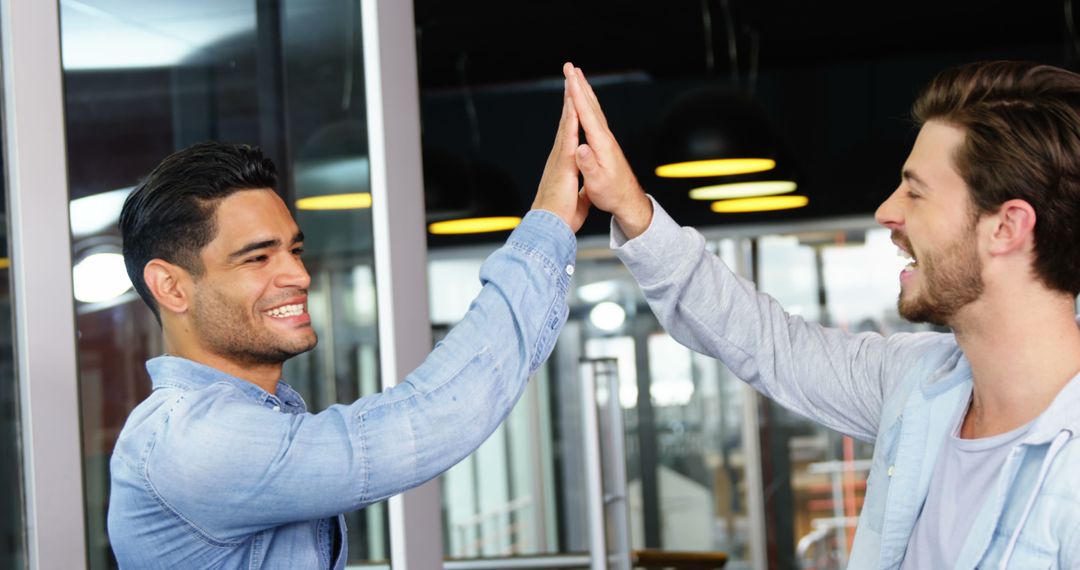 Two Happy Men High-Fiving in Office Environment - Free Images, Stock Photos and Pictures on Pikwizard.com