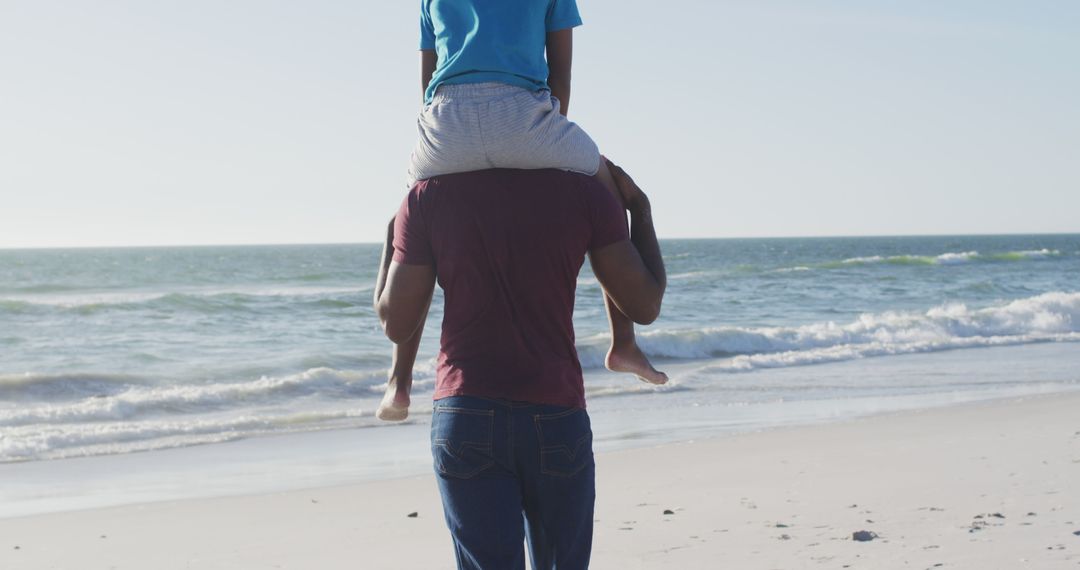 Father Carrying Child on Shoulders by the Beach - Free Images, Stock Photos and Pictures on Pikwizard.com