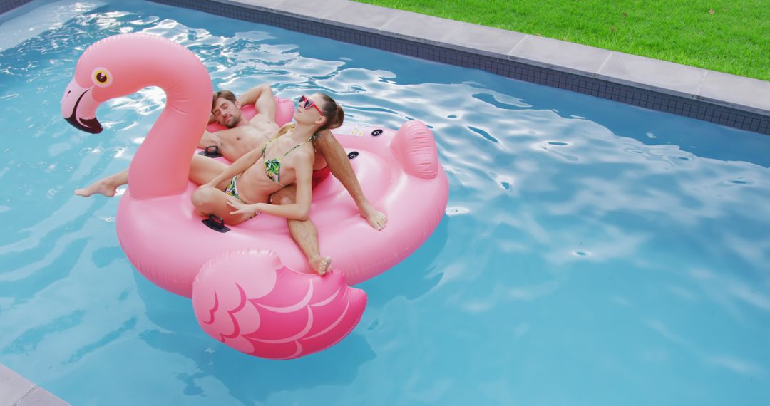 Couple Relaxing on Pink Flamingo Float in Swimming Pool - Free Images, Stock Photos and Pictures on Pikwizard.com