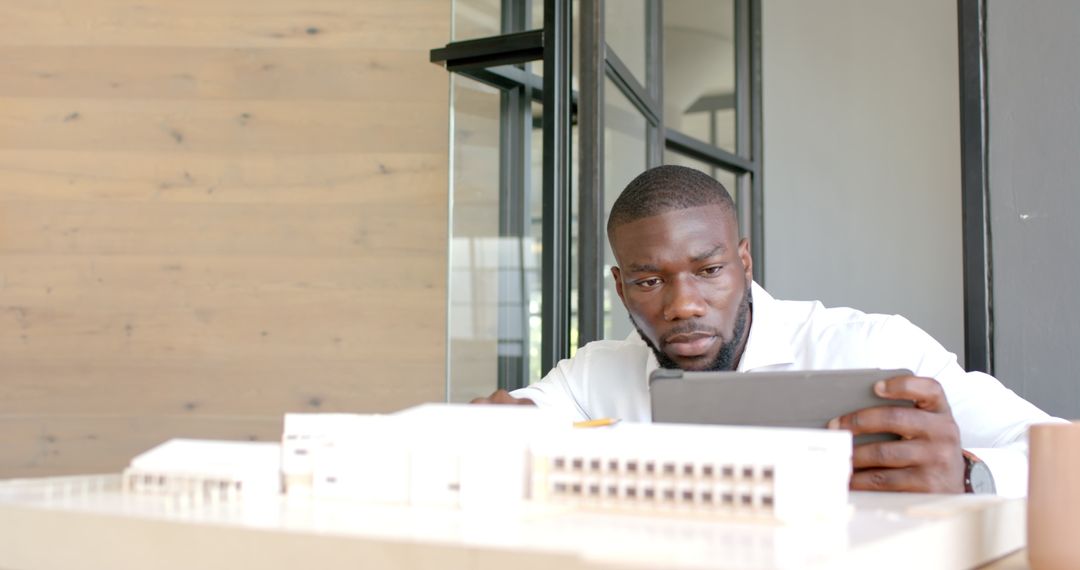 Architect Analyzing Building Model Using Tablet in Office