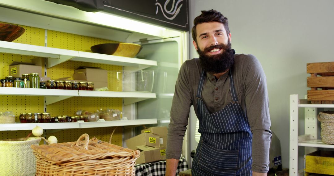 Bearded man in apron working at local organic store counter - Free Images, Stock Photos and Pictures on Pikwizard.com