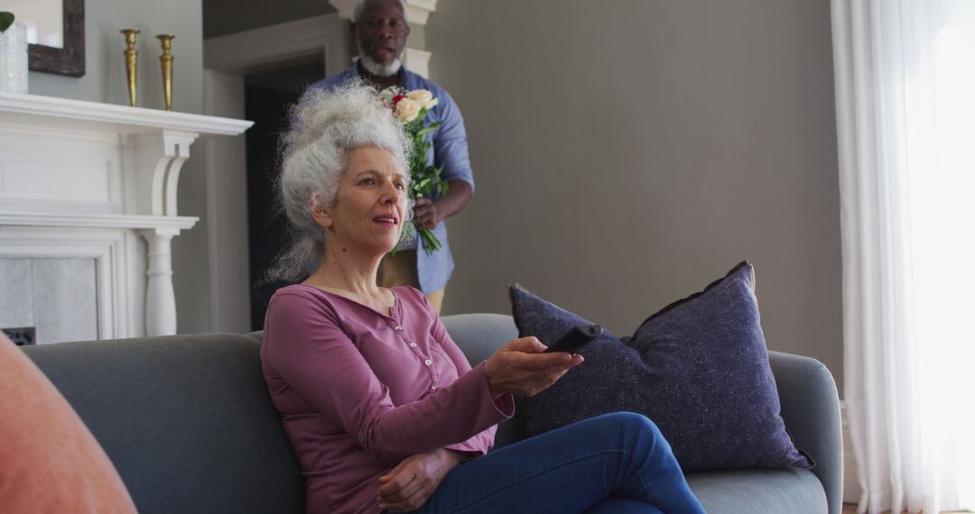 Senior Couple Relaxing at Home, Watching TV and Holding Flowers - Free Images, Stock Photos and Pictures on Pikwizard.com