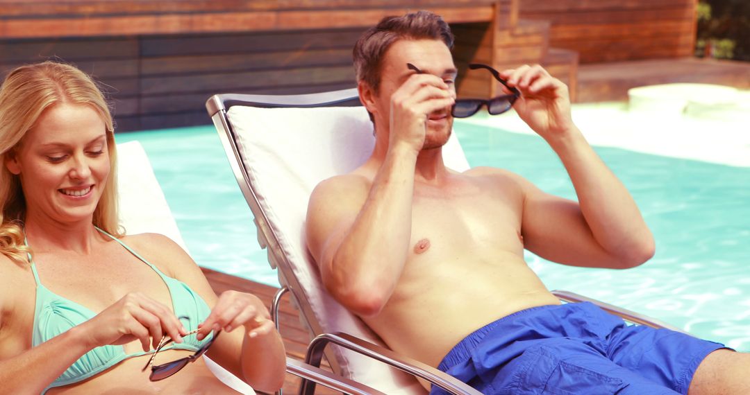 Smiling couple wearing sunglasses poolside - Free Images, Stock Photos and Pictures on Pikwizard.com