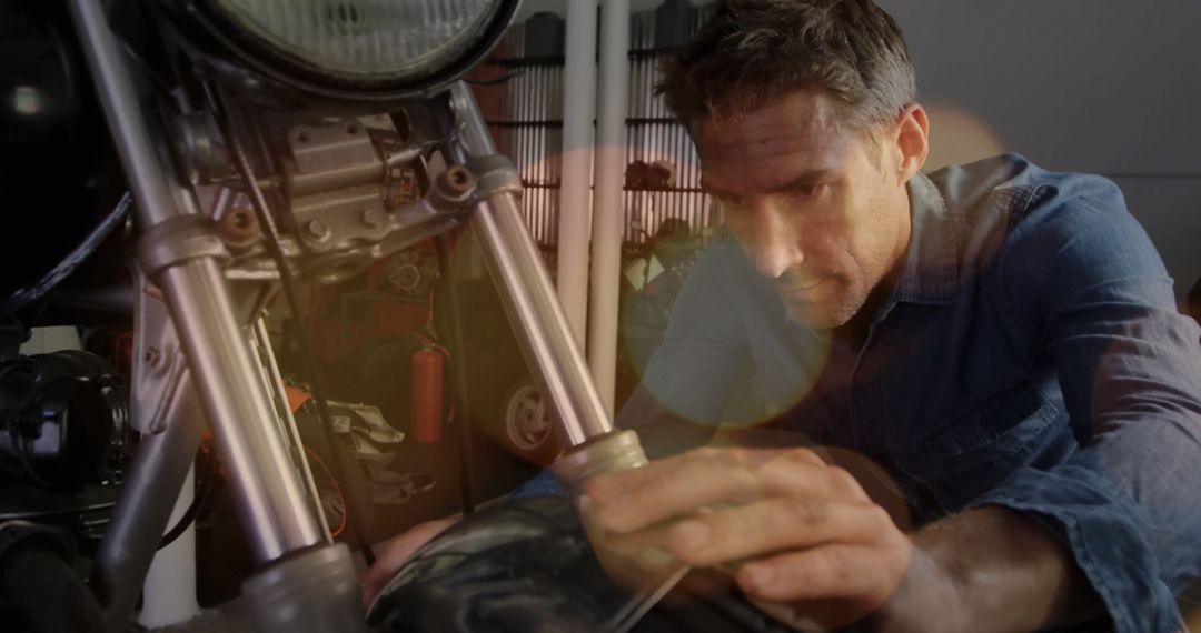 Mechanic Focusing on Motorcycle Fork Adjustment in Rustic Workshop