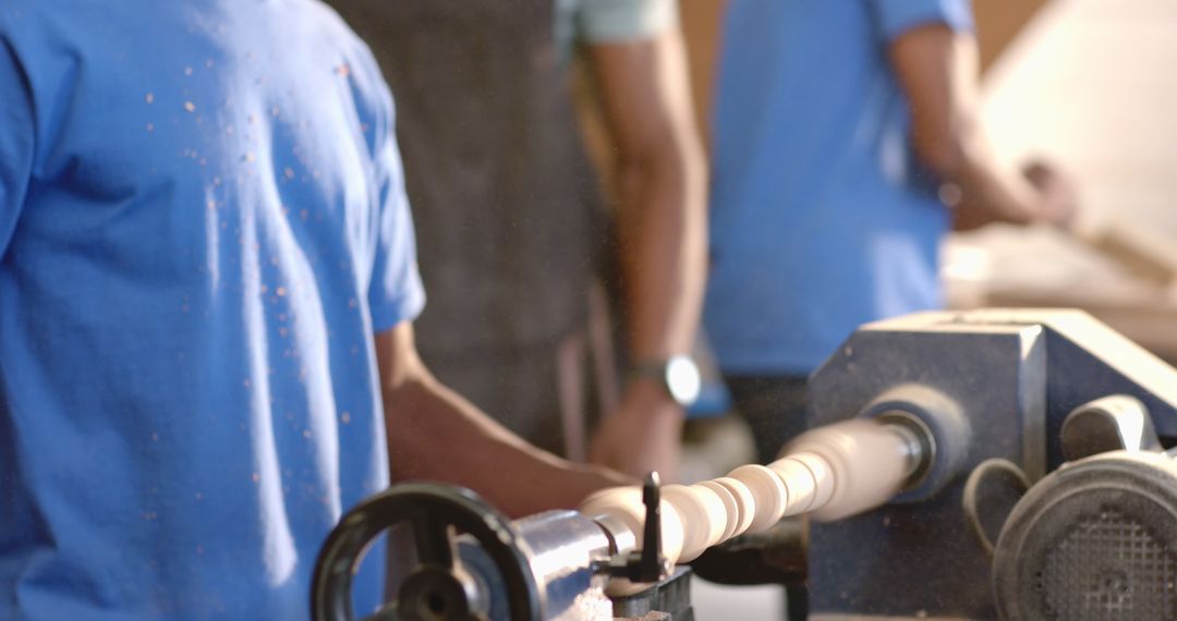 Collaborative Woodworking Brothers Using Lathe in Dusty Workshop